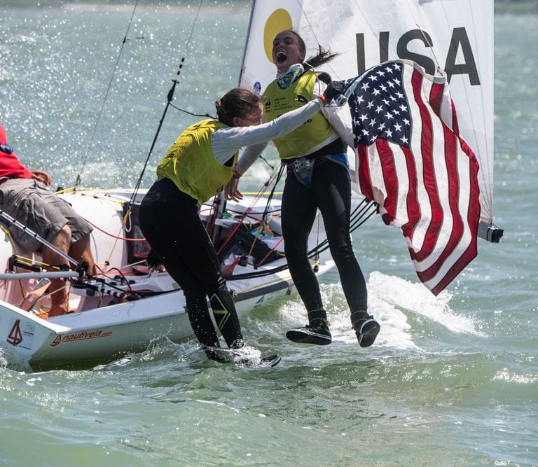 Carmen (center) and Emma Cowles celebrate their gold medal in the Girls' 420 Class (Jen Edney/World Sailing photo).