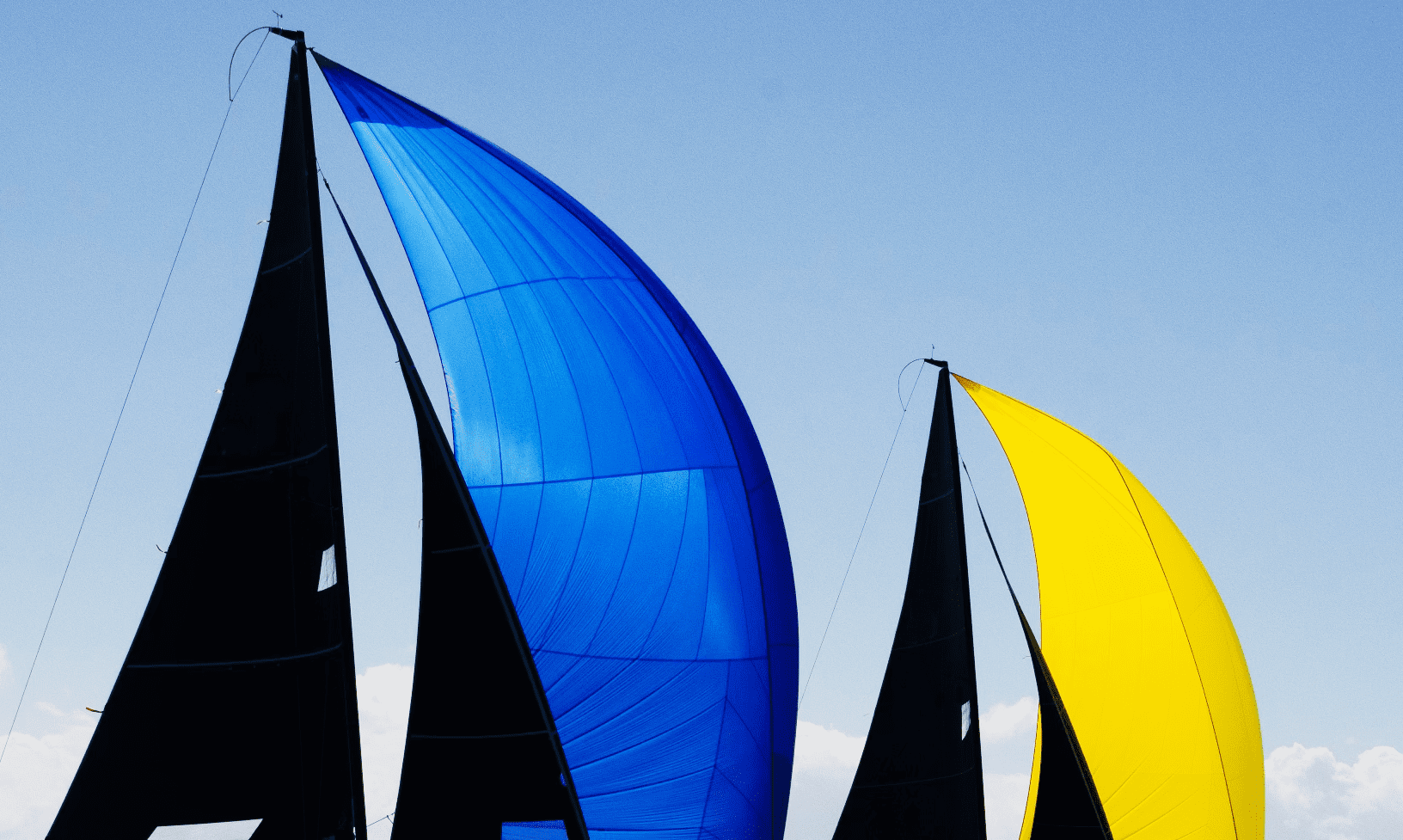 Photos of blue and yellow spinnaker sailboats